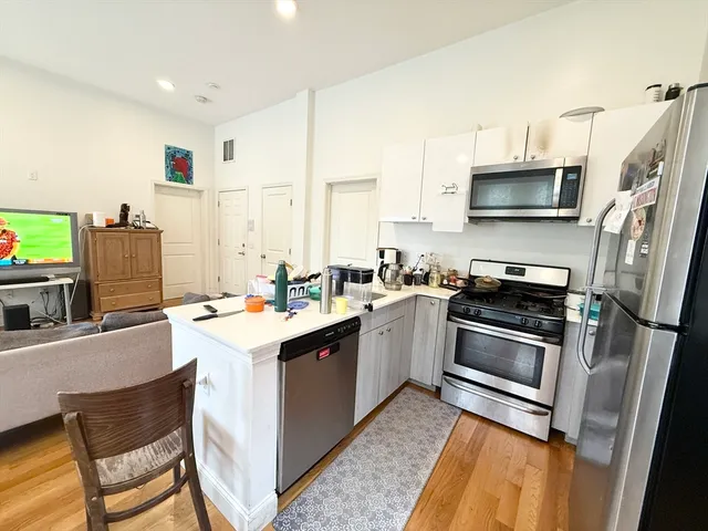 a kitchen with a sink a stove and chairs