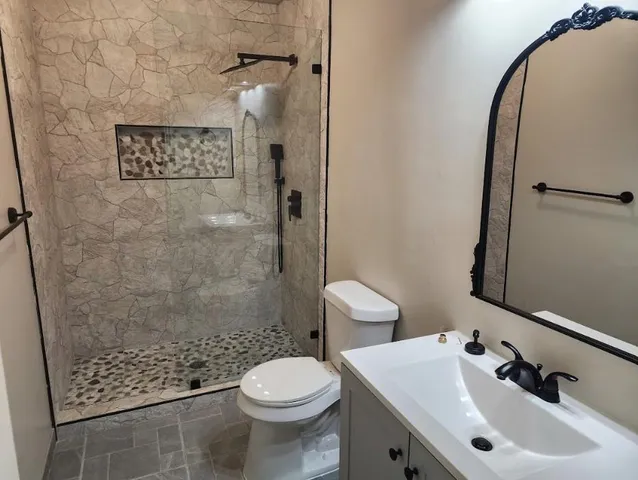 a bathroom with a sink a toilet and shower