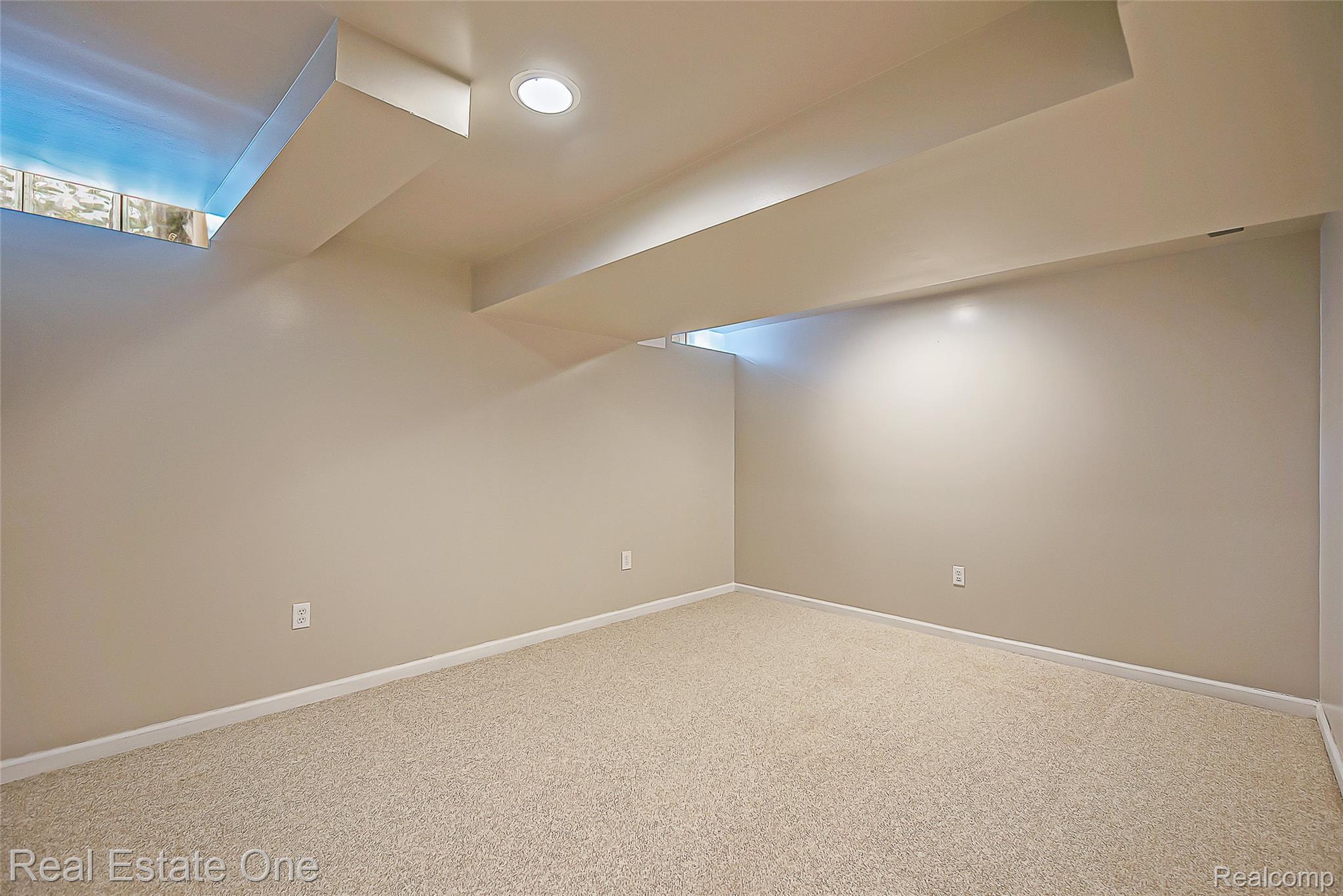 1013 Rochelle Park Drive Rochester, MI 48307 - Photo 54 of 74 Recessed lighting, light-colored carpeting, neutral wall paint, and a block glass window