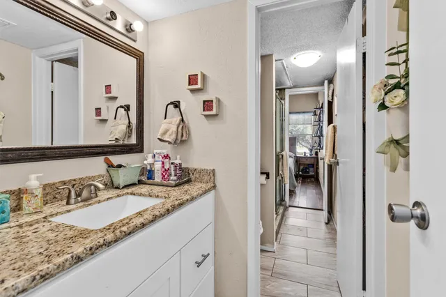 a bathroom with a granite countertop sink and a mirror