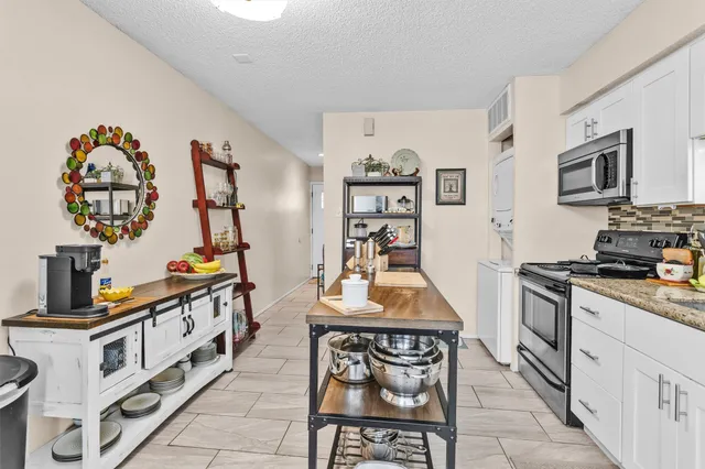 a kitchen with stainless steel appliances a stove top oven a sink a counter space and cabinets