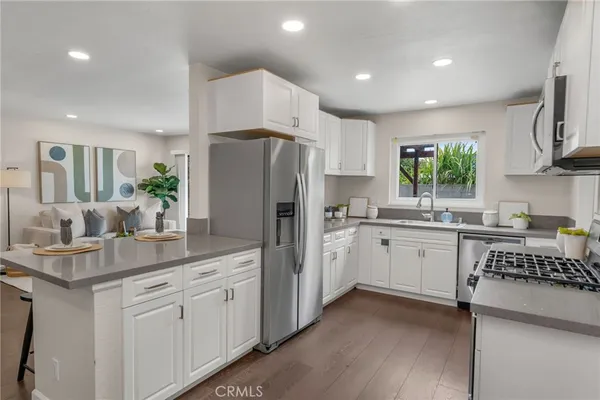 a kitchen with white cabinets and refrigerator