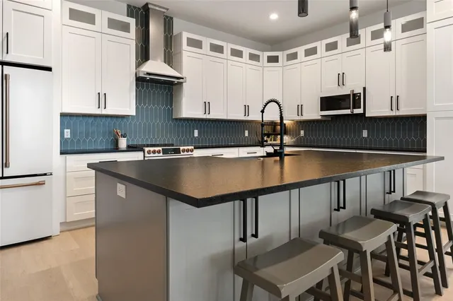 a kitchen with stainless steel appliances granite countertop a sink and cabinets