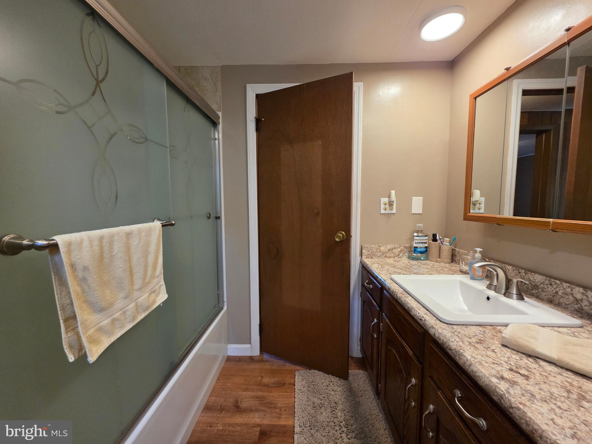 951 Johnsons Mill Road Berkeley Springs, WV 25411 - Photo 25 of 66 a en suite bathroom with a granite countertop sink and a mirror