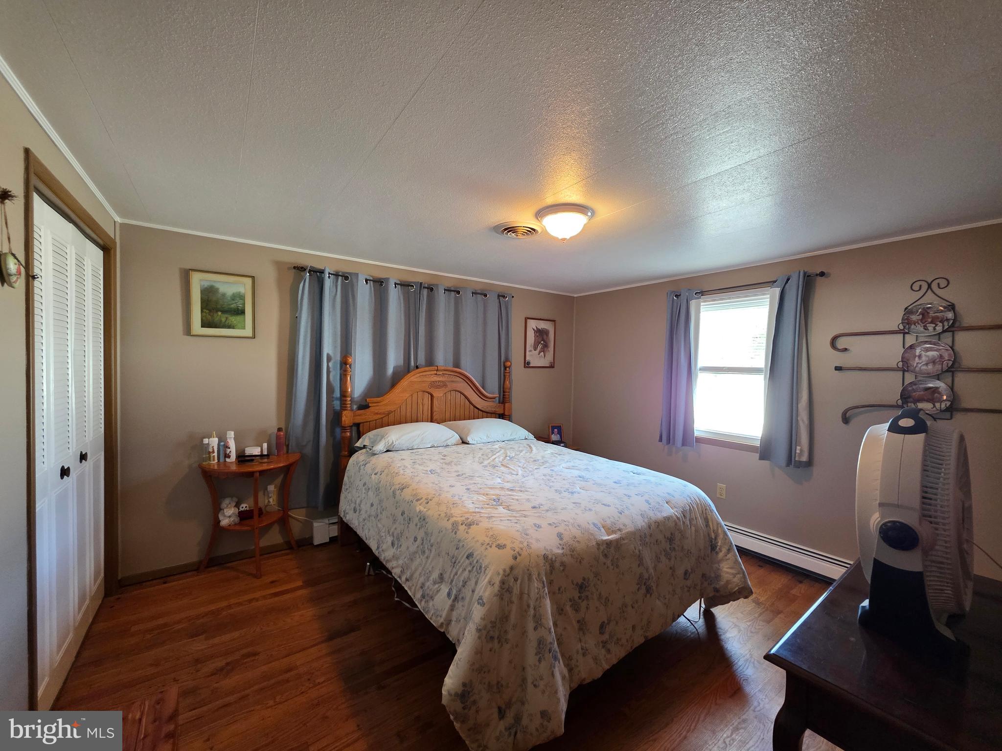 951 Johnsons Mill Road Berkeley Springs, WV 25411 - Photo 26 of 66 a bed sitting in a bedroom next to a window