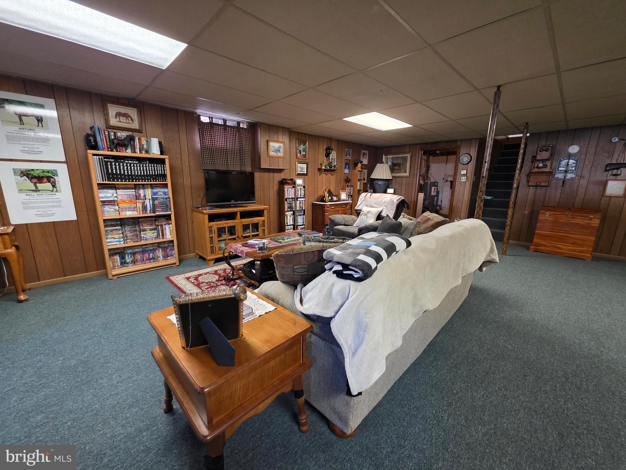 951 Johnsons Mill Road Berkeley Springs, WV 25411 - Photo 36 of 66 a living room with furniture a flat screen tv and a book shelf