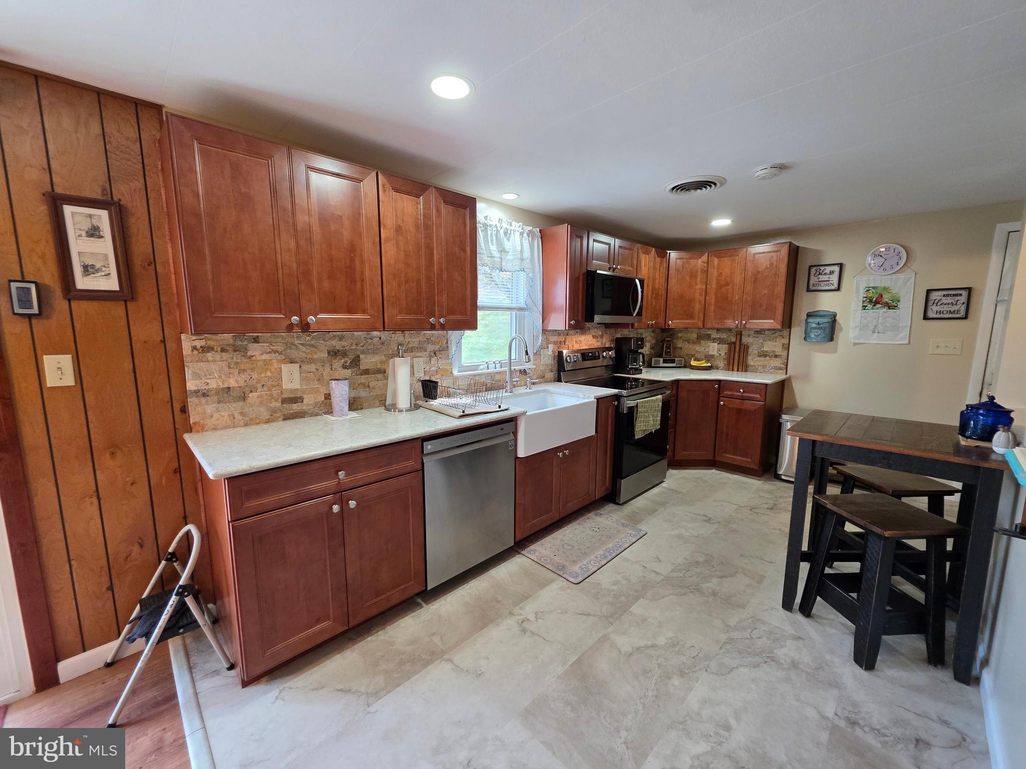 951 Johnsons Mill Road Berkeley Springs, WV 25411 - Photo 5 of 66 a kitchen with stainless steel appliances granite countertop wooden cabinets a stove top oven a sink and dishwasher