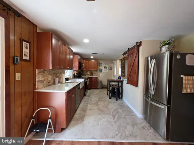 a kitchen with refrigerator and chairs