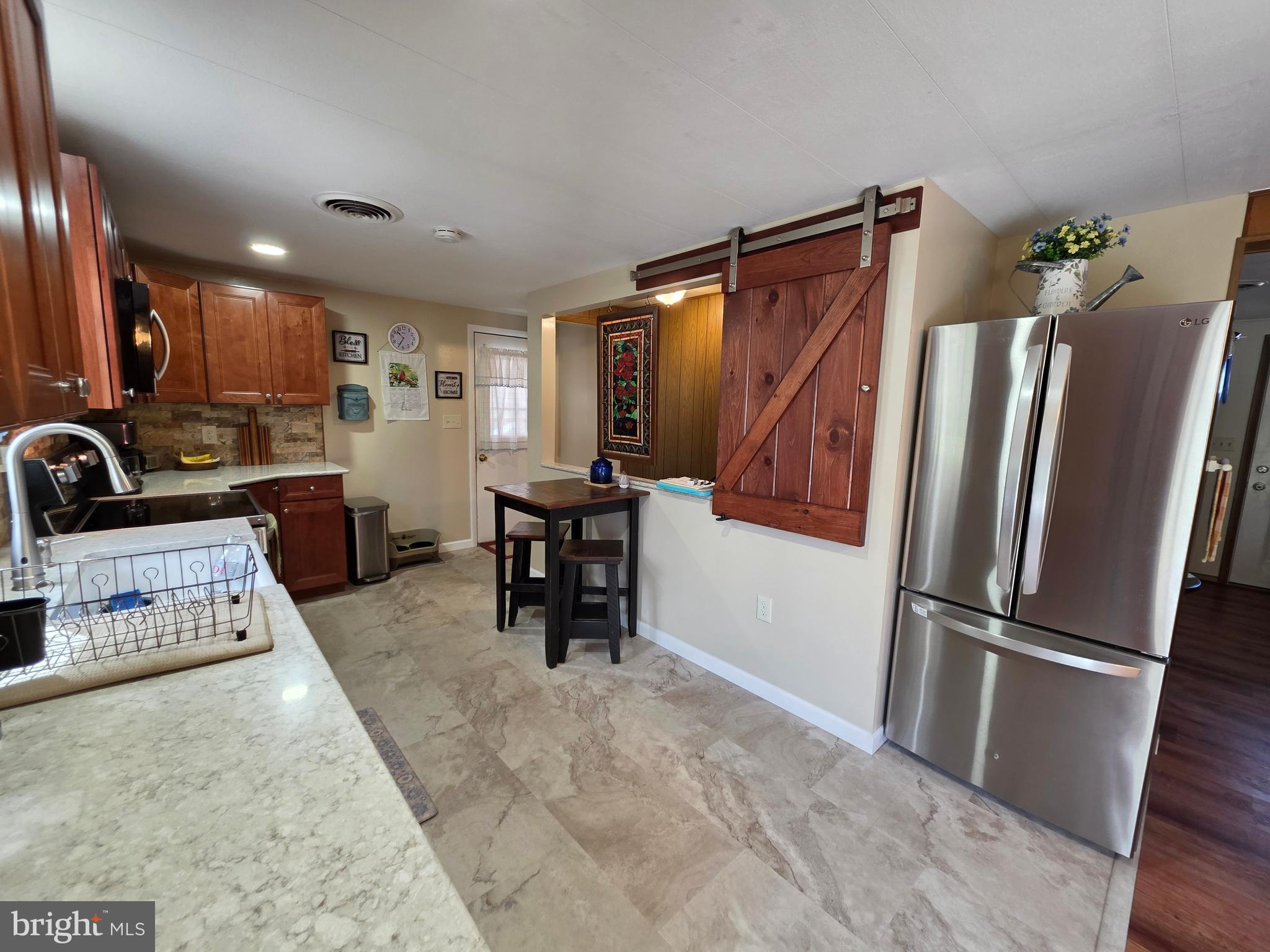 951 Johnsons Mill Road Berkeley Springs, WV 25411 - Photo 7 of 66 a kitchen with refrigerator and chairs