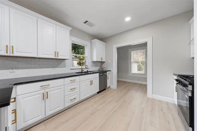a kitchen with granite countertop white cabinets and white appliances