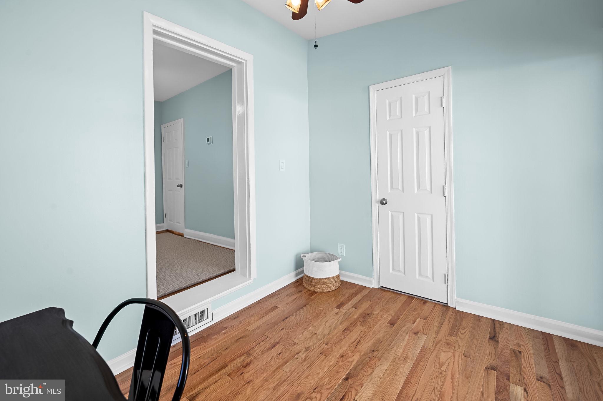 7922 Underhill Road Rosedale, MD 21237 - Photo 27 of 41 an empty room with wooden floor and mirror