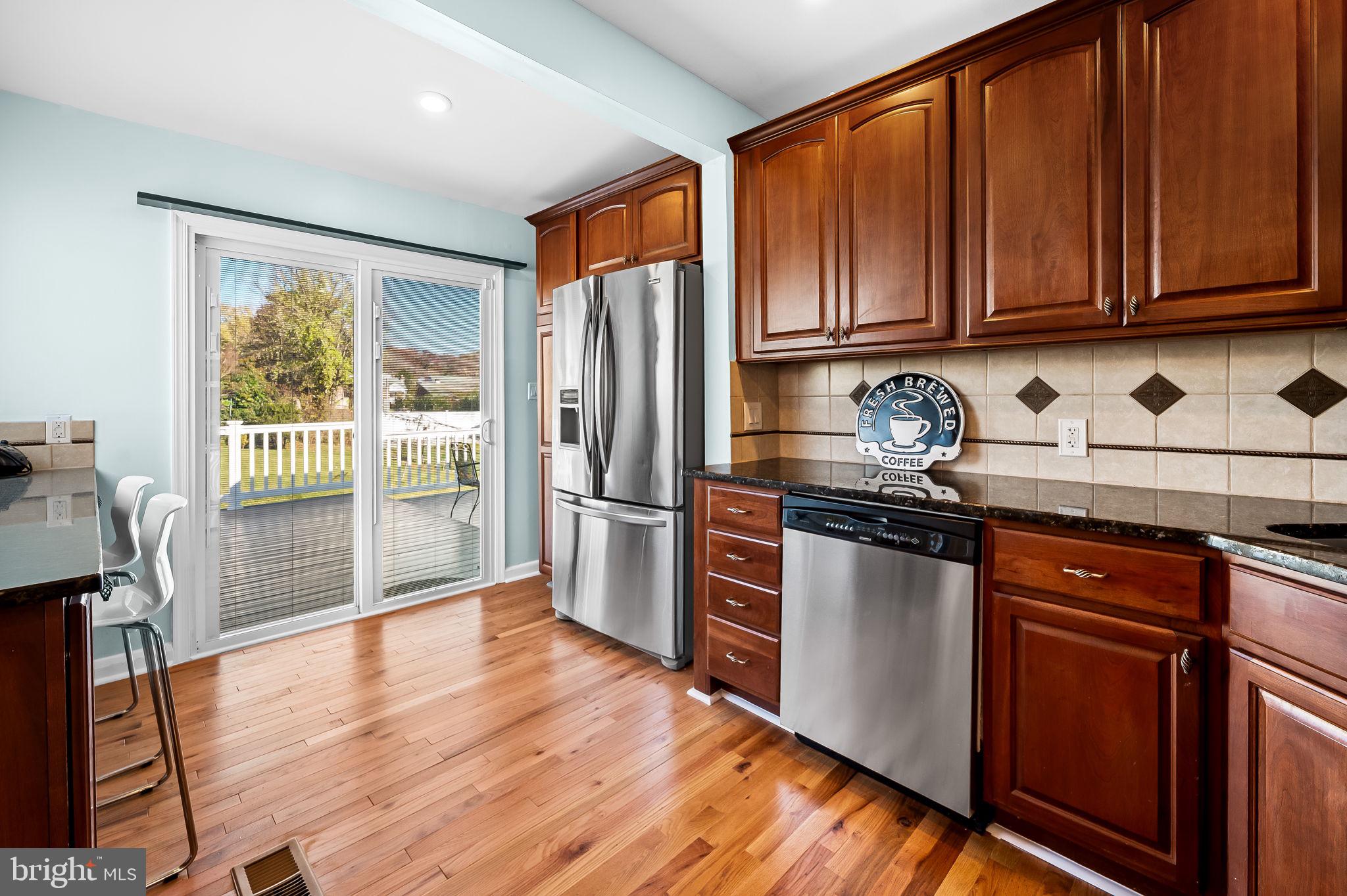 7922 Underhill Road Rosedale, MD 21237 - Photo 9 of 41 a kitchen with stainless steel appliances granite countertop a refrigerator stove and wooden cabinets
