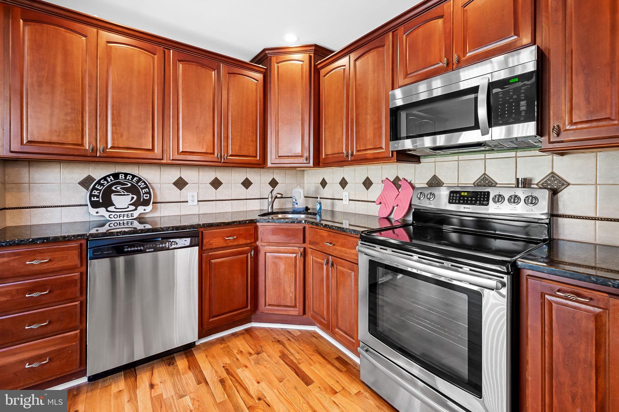 7922 Underhill Road Rosedale, MD 21237 - Photo 10 of 41 a kitchen with stainless steel appliances granite countertop a stove a sink and a microwave