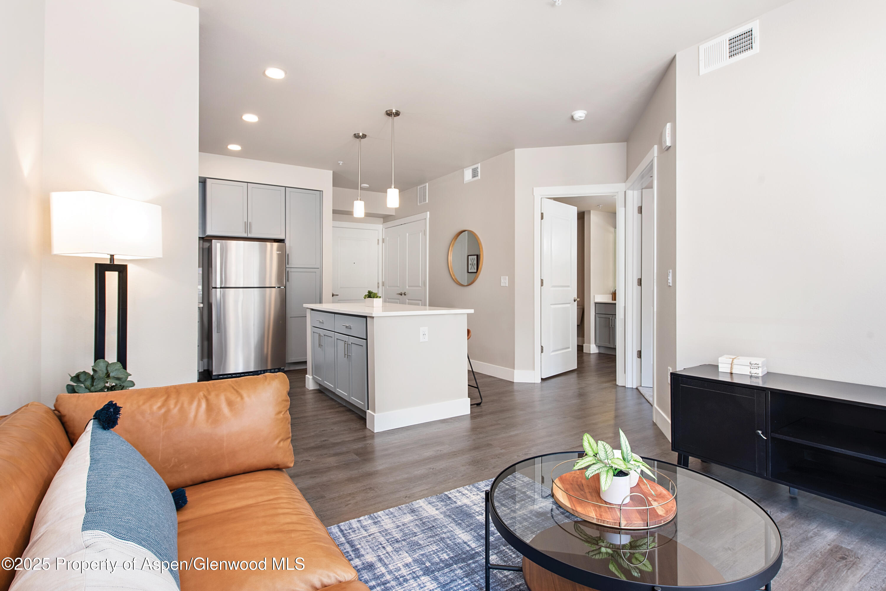 253 Wulfsohn Road, Unit 110 Glenwood Springs, CO 81601 - Photo 18 of 45 a living room with kitchen island furniture and a wooden floor
