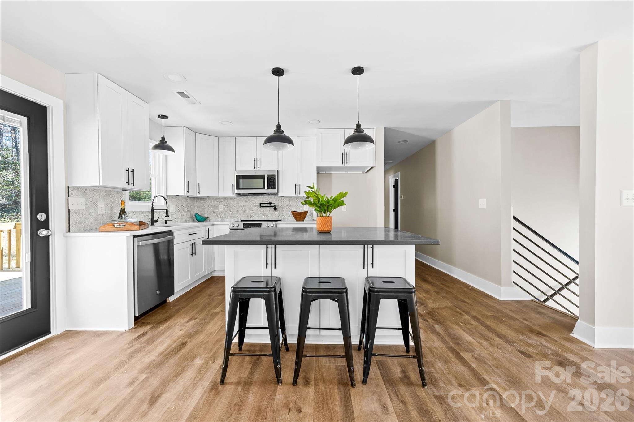 205 Redding Road Stanley, NC 28164 - Photo 9 of 34 a kitchen with stainless steel appliances a dining table chairs and wooden floor