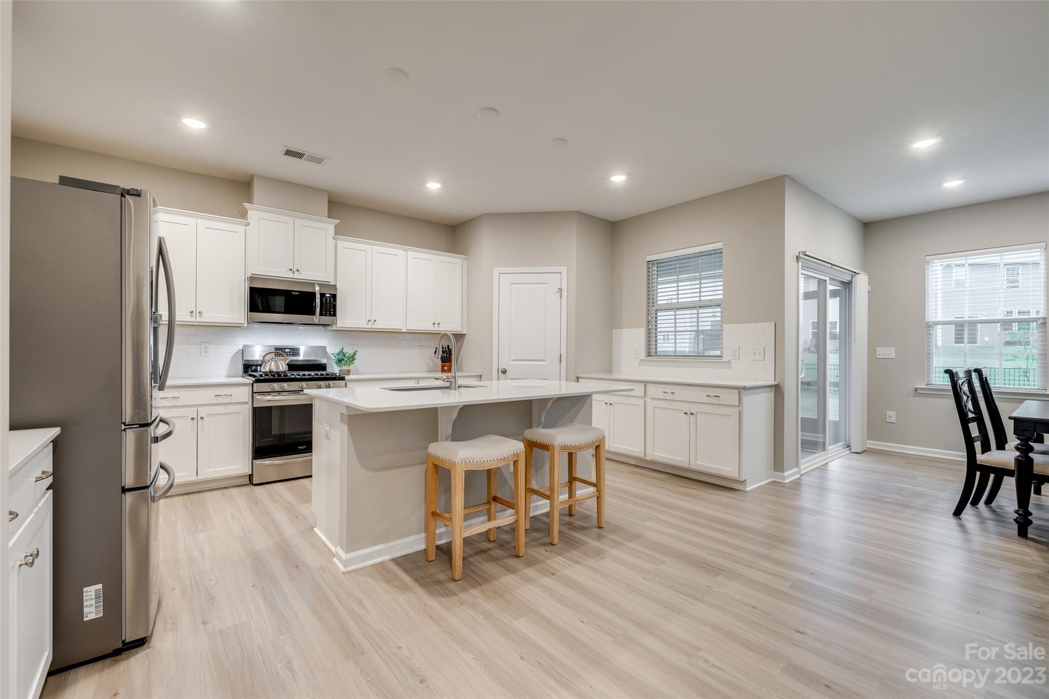1656 Corwin Bend Road Tega Cay, SC 29708 - Photo 14 of 47 a kitchen with white cabinets and stainless steel appliances