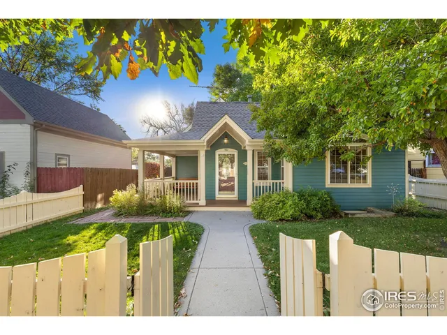 a front view of house with yard and trees in the background