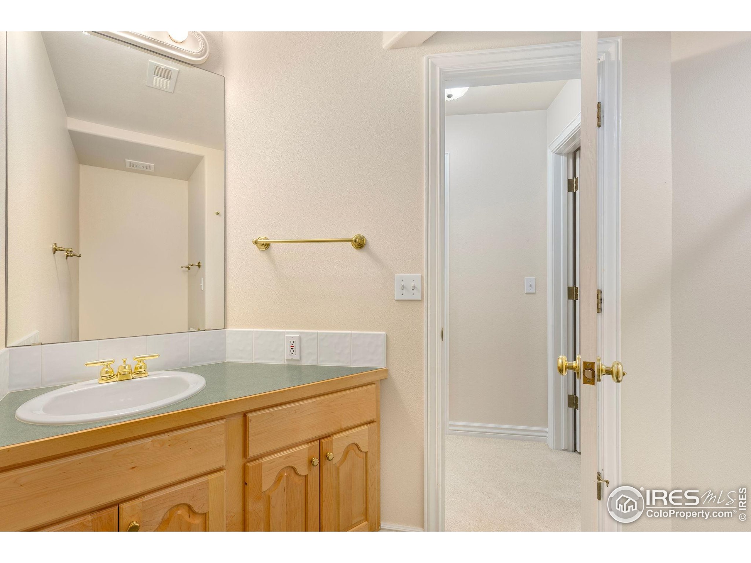 961 5th Street Berthoud, CO 80513 - Photo 23 of 35 a bathroom with a sink a mirror and a shower