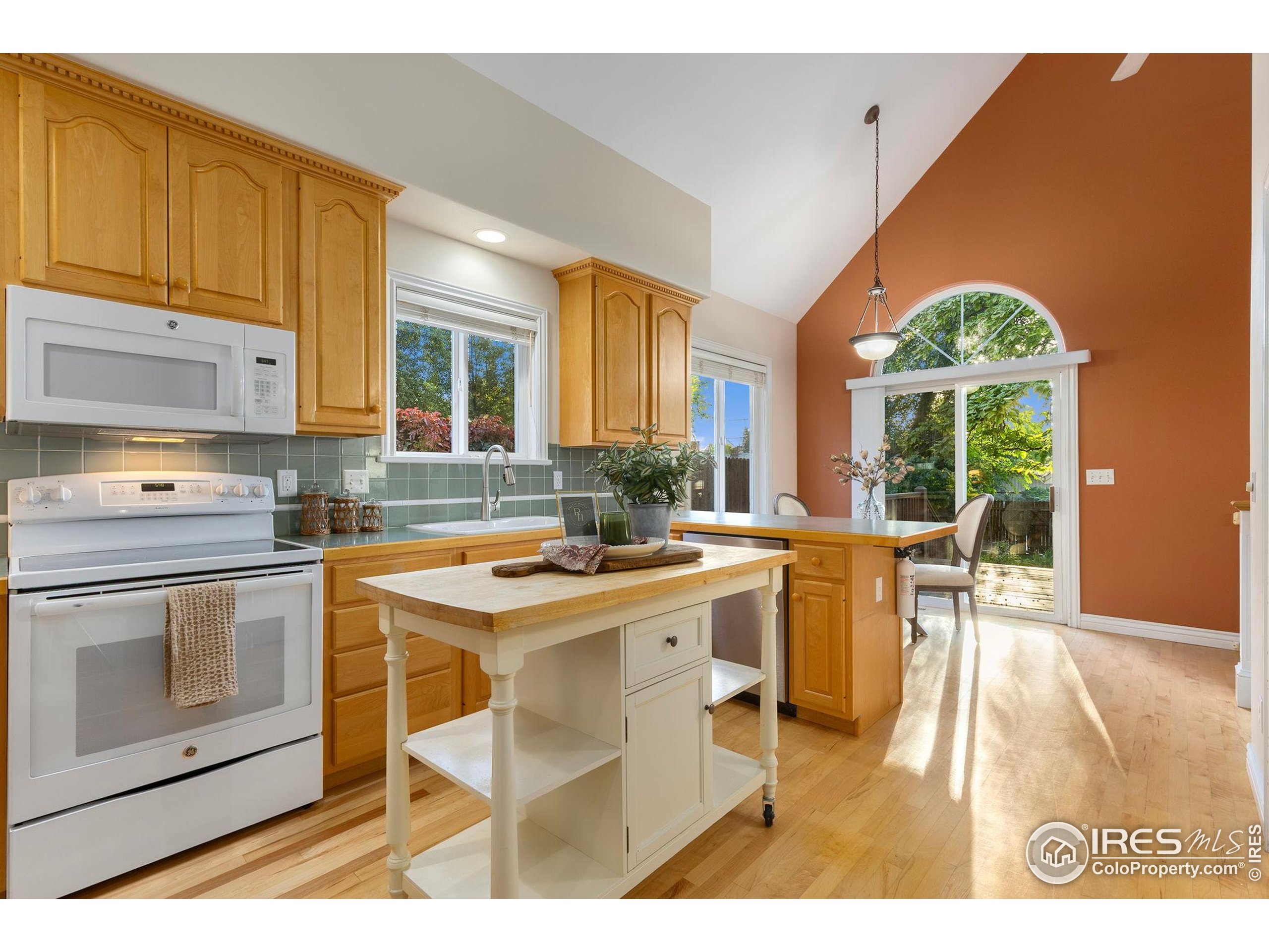 961 5th Street Berthoud, CO 80513 - Photo 8 of 35 a kitchen with a stove a sink a dining table and chairs