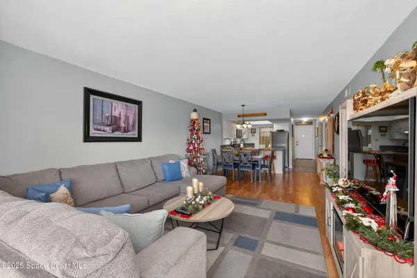 a living room with furniture a flat screen tv and a floor to ceiling window