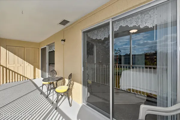 a balcony with table and chairs