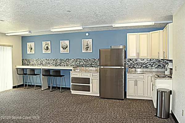 a kitchen with stainless steel appliances granite countertop a refrigerator and a stove top oven