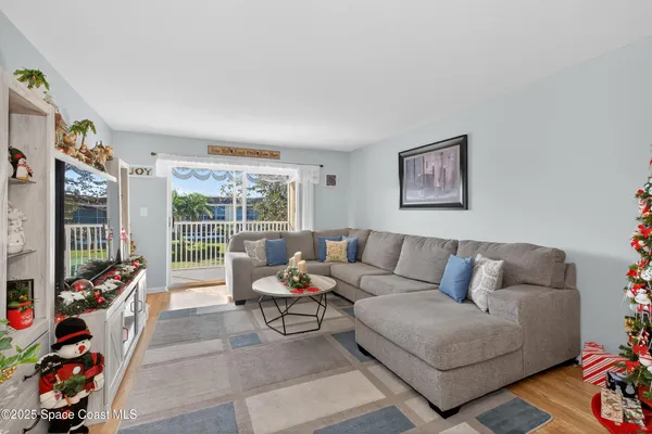 a living room with furniture a flat screen tv and a floor to ceiling window
