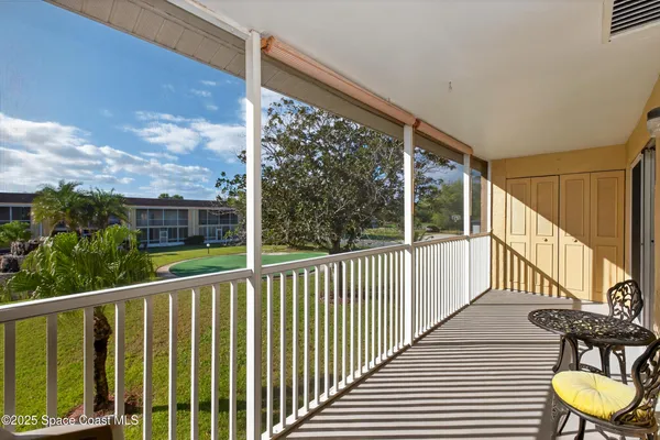 a view of a balcony with chair and wooden floor