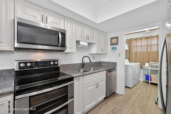 a kitchen with stainless steel appliances a stove microwave and sink