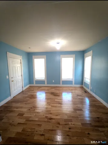 a view of empty room with window and wooden floor