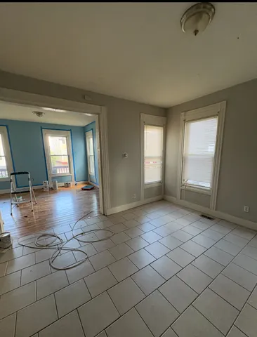 an empty room with windows and view of bathroom