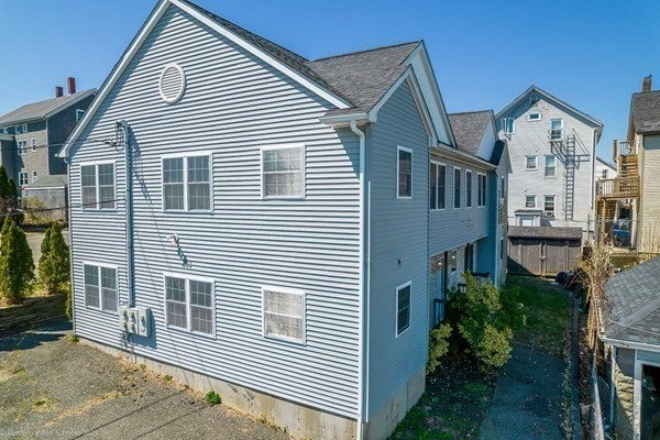 303 Eagle Street, Unit D Fall River, MA 02721 - Photo 4 of 24 a view of a house with a yard and potted plants
