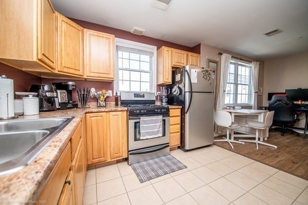 303 Eagle Street, Unit D Fall River, MA 02721 - Photo 6 of 24 a kitchen with refrigerator and cabinets