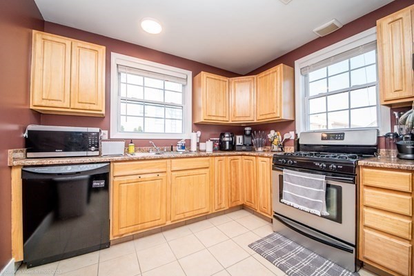 303 Eagle Street, Unit D Fall River, MA 02721 - Photo 8 of 24 a kitchen with stainless steel appliances granite countertop a stove a sink and a microwave