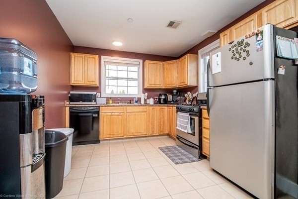 303 Eagle Street, Unit D Fall River, MA 02721 - Photo 9 of 24 a kitchen with stainless steel appliances granite countertop a refrigerator sink and cabinets