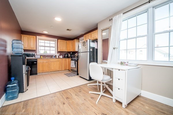 303 Eagle Street, Unit D Fall River, MA 02721 - Photo 10 of 24 a kitchen with a table chairs refrigerator and cabinets