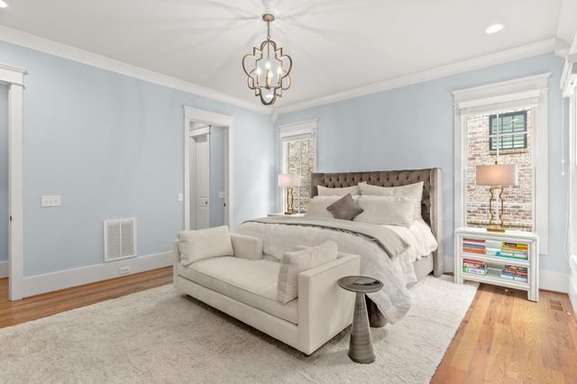 a spacious bedroom with a bed and a wooden floor