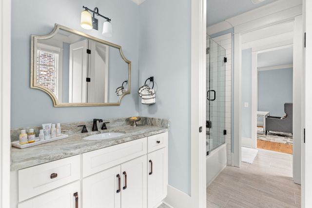 a en suite bathroom with a granite countertop sink and a mirror