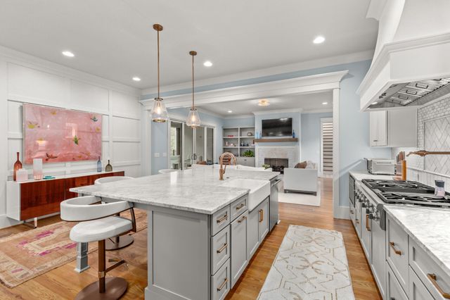 a kitchen with a sink stove and wooden floor