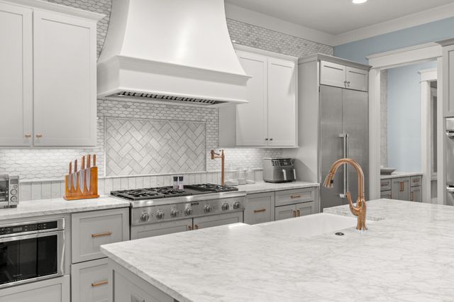 a kitchen with granite countertop a stove a sink and a microwave