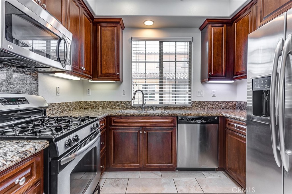 135 Silverado Irvine, CA 92618 - Photo 7 of 23 a kitchen with stainless steel appliances granite countertop a stove sink and cabinets
