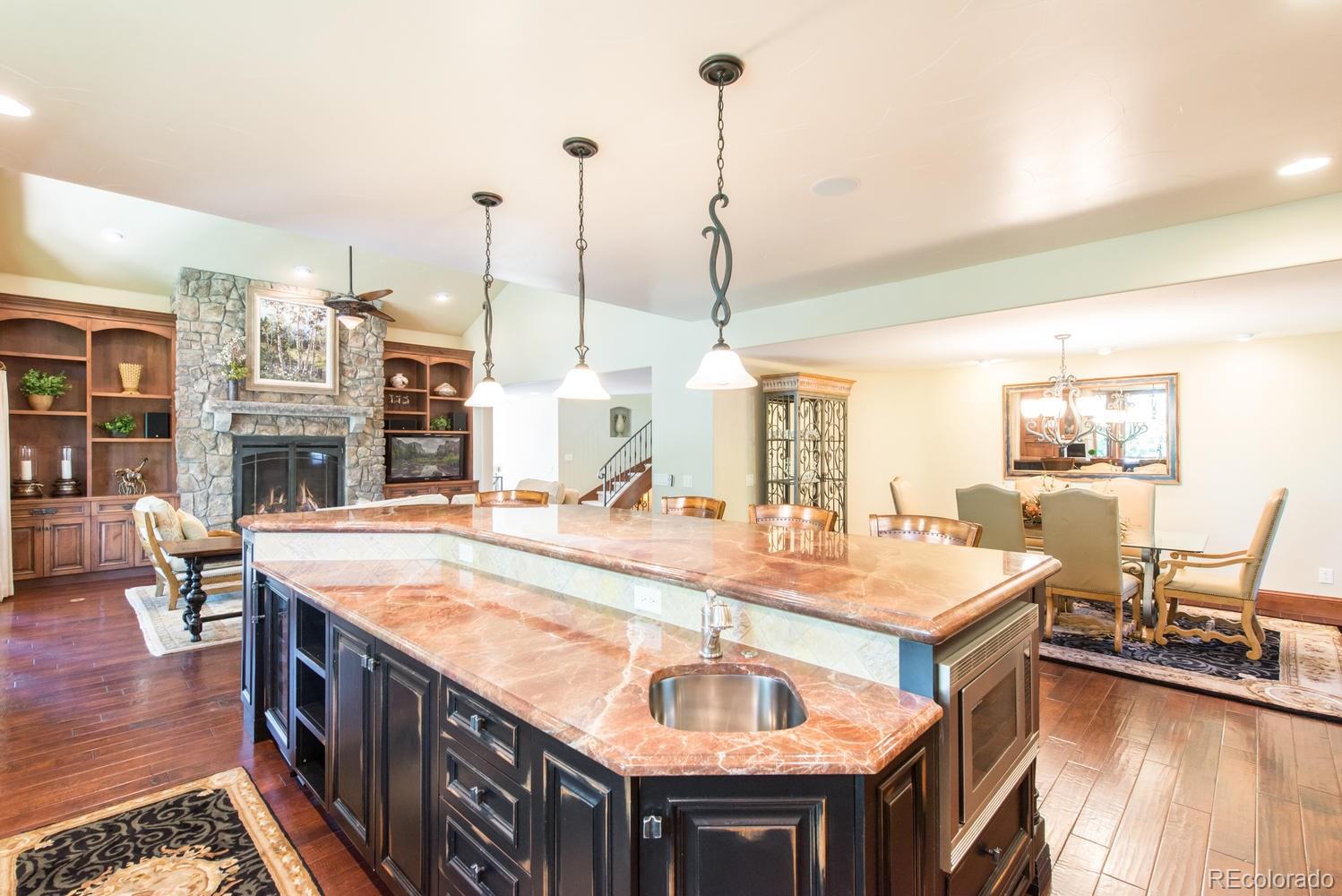 45 West Ranch Trail Morrison, CO 80465 - Photo 12 of 35 a kitchen with stainless steel appliances granite countertop a sink and a wooden floor