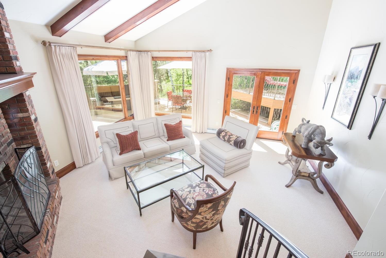 45 West Ranch Trail Morrison, CO 80465 - Photo 13 of 35 a living room with furniture a flat screen tv and a large window