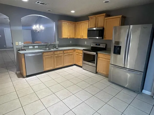 a kitchen with granite countertop cabinets and steel stainless steel appliances with a refrigerator