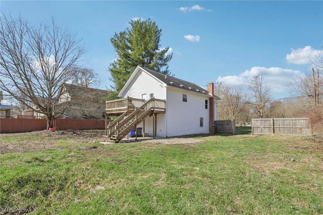 4200 Hattrick Road Rootstown, OH 44272 - Photo 37 of 42 Rear view of house with a fenced backyard, a deck, and a chimney