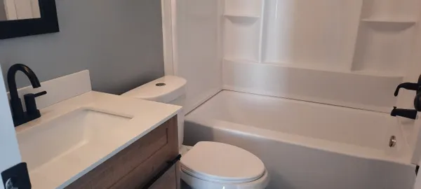 a white toilet sitting next to a bath tub