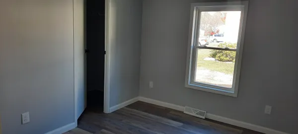 a room with wooden floor and a window