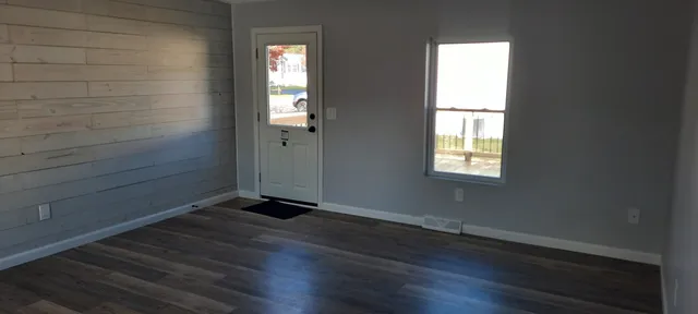 a small space with wooden floor and a window