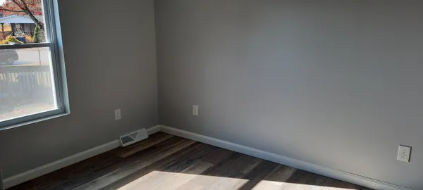 a small space with wooden floor and a window