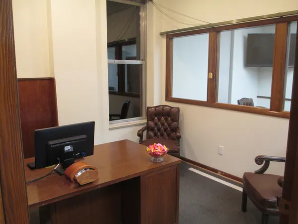 a room with stainless steel appliances wooden floor and view of kitchen